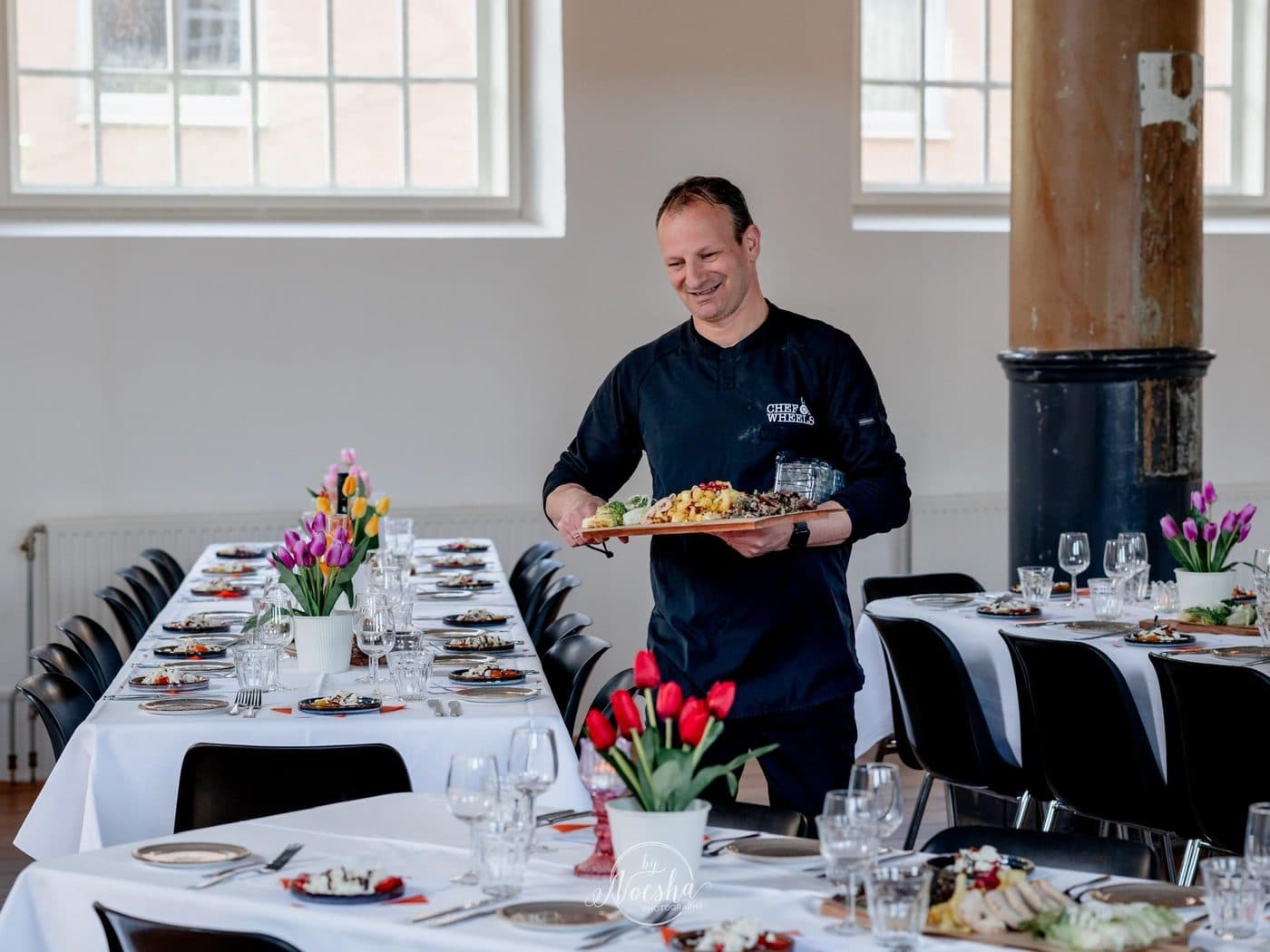 Chanan met een schaal hapjes aan een gedekte tafel